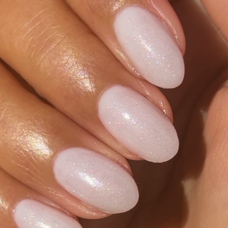 The Celestial Effect Top Coat creating a soft white manicure with subtle sparkling micro-shimmer on natural nails