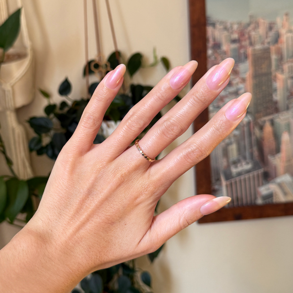 Champagne Chiffon - Builder Gel on almond-shaped nails with natural sheer golden iridescent manicure indoors