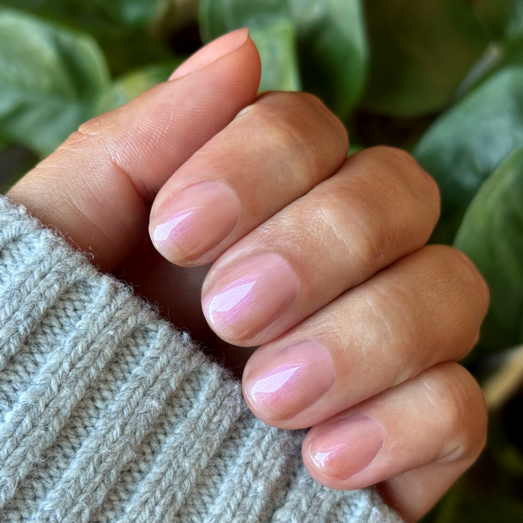 Champagne Chiffon - Builder Gel on short natural nails with a soft sheer golden iridescent manicure against cozy background