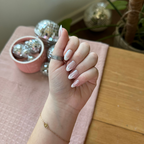 Chrome French - Press-On | Medium | Oval showing glossy medium oval false nails with thick white french tips on hand indoors