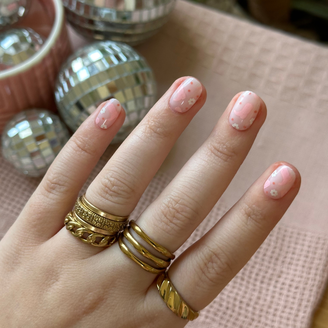 Cowgirl Boot Boogie - Press-On | Extra Short | Round showing soft pink floral press-on false nails on hand with gold rings indoors