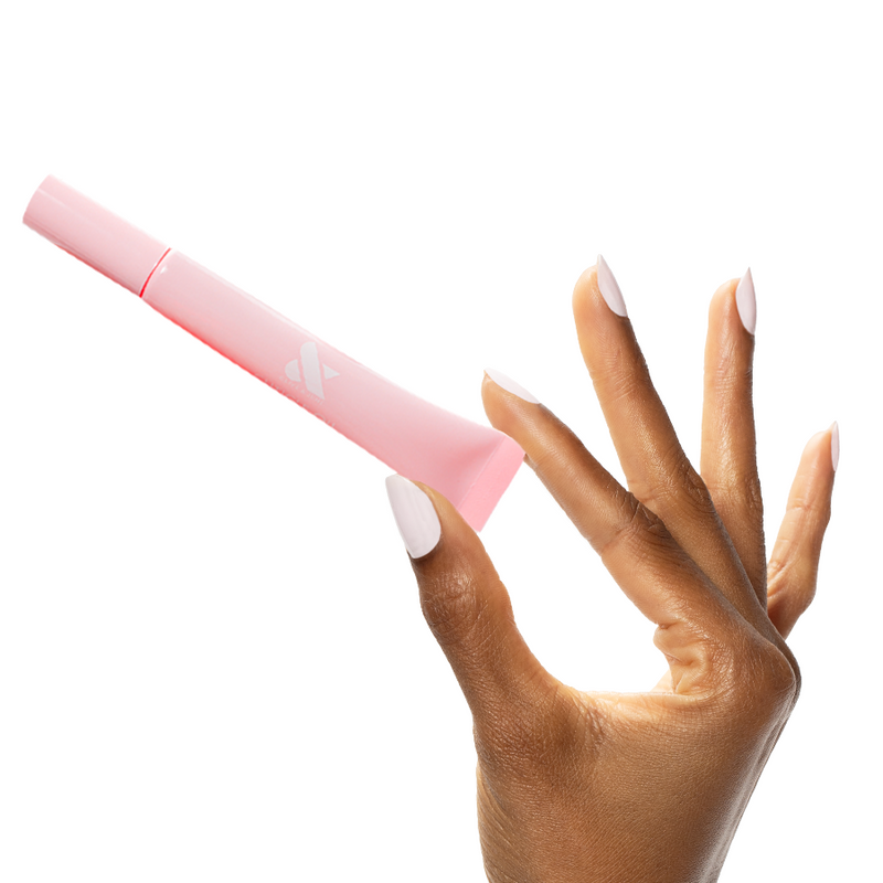 Hand holding a pink tube of Cuticle Oil with well-manicured nails showcasing hydration for healthy nail care.