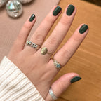 Hand displaying glossy nails painted in One For You, Two For Me gel polish by Olive and June in dark emerald green