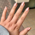 Hand with Penny polish showing smooth shiny copper metallic manicure on natural skin with neutral background