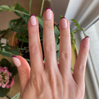 Plum Tonal French - Press-On | Short | Round showing hand with short round nails featuring plum french tips by window with plants background