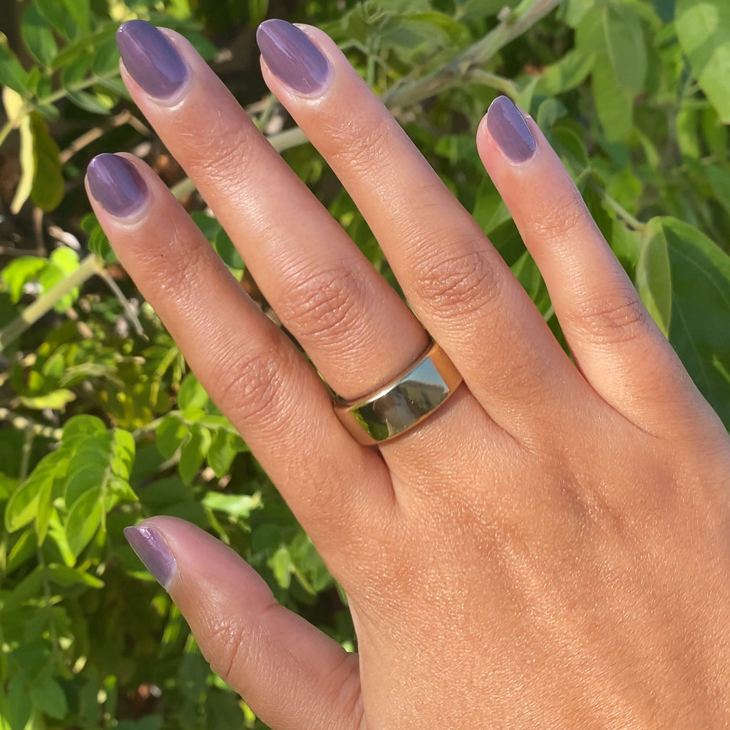 Hand showing a smooth Twilight gel polish manicure in iridescent violet on medium skin with natural sunlight outdoors