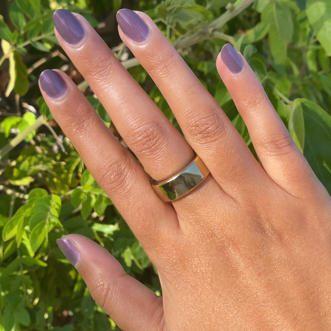 Hand showing a smooth Twilight gel polish manicure in iridescent violet on medium skin with natural sunlight outdoors