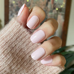 Tutu | Short | Squoval - Tab Press-On showing soft pastel pink false nails on hand wearing knitted sweater for easy mani.