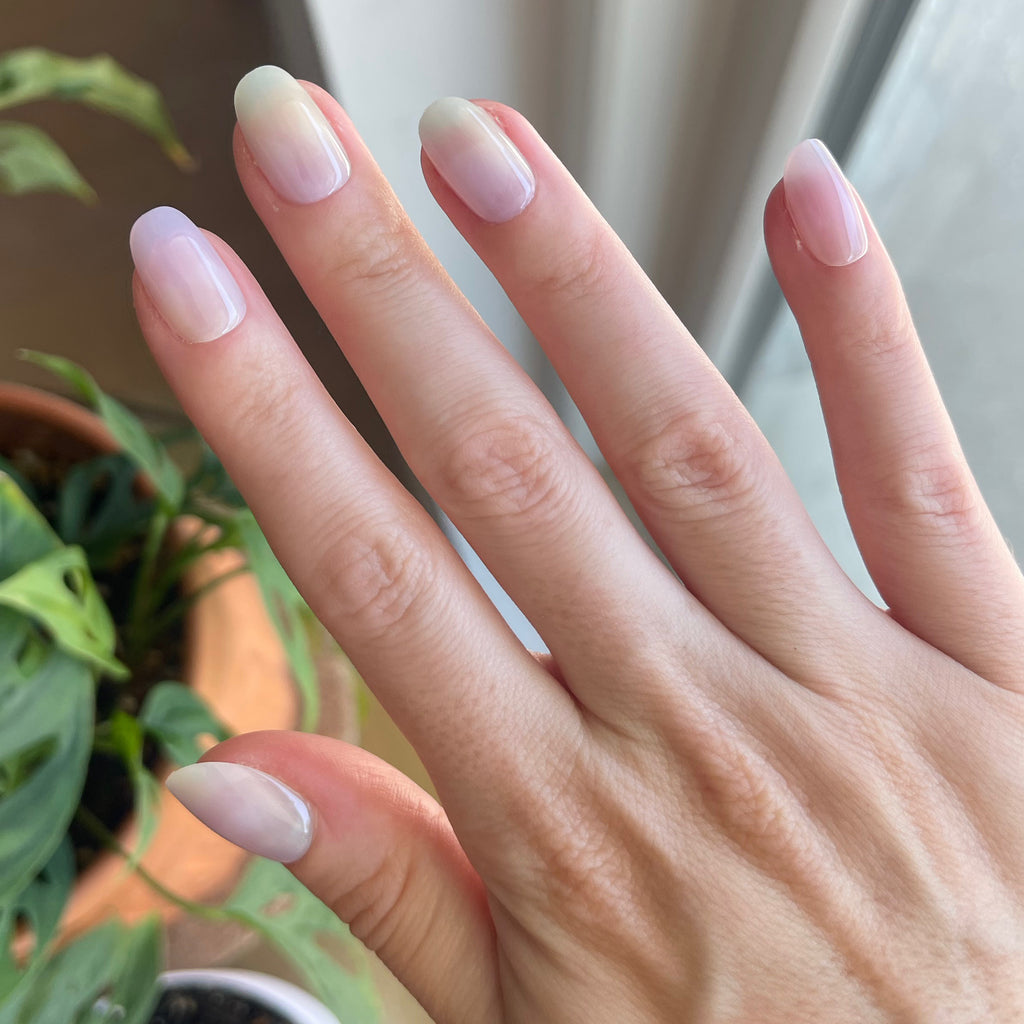 Tie Dye - Press-On | Short | Round showing natural short round nails with subtle pastel gradient near green indoor plants