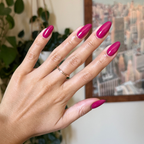 Hand with natural nails painted in vibrant Darling hot magenta gel polish showing glossy quick dry manicure
