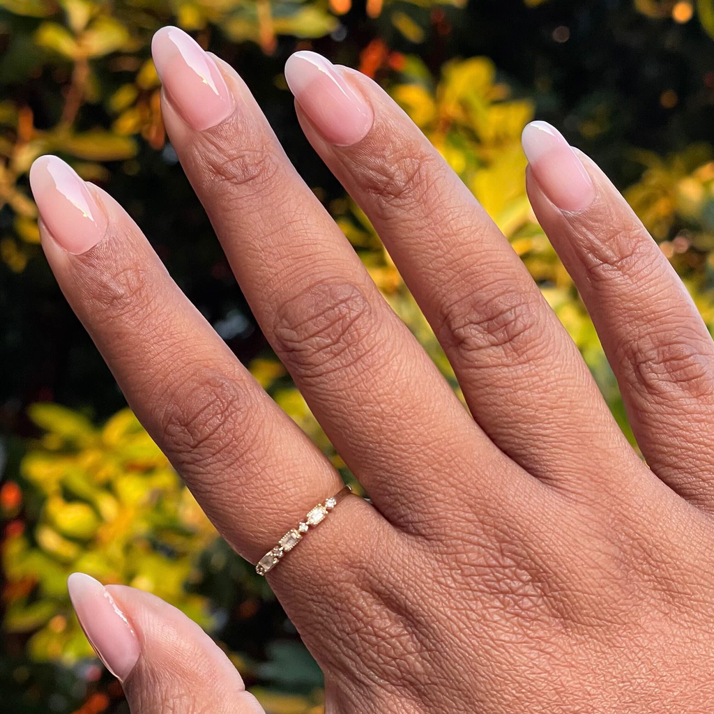 Flora Aura - Builder Gel on natural almond-shaped nails with a delicate sheer cool pink gel manicure outdoors