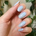 The Golden Effect Top Coat adding a soft gilded shimmer over pastel blue gel polish for a glowing long-lasting mani thumbnail