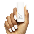 HD - Gel bottle held by hand with smooth, glossy white gel polish on medium-length natural nails for an at-home mani