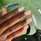 HZ - Gel neutral rosy gel polish manicure on medium-length nails with natural light and green leaf background