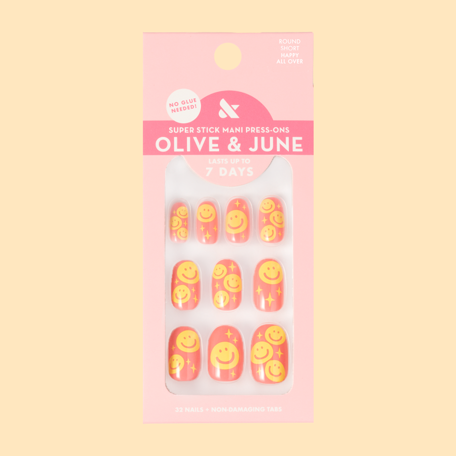 Happy All Over | Short | Round - Tab Press-On nails featuring pink base and cheerful yellow smiley face print for a bright mani look