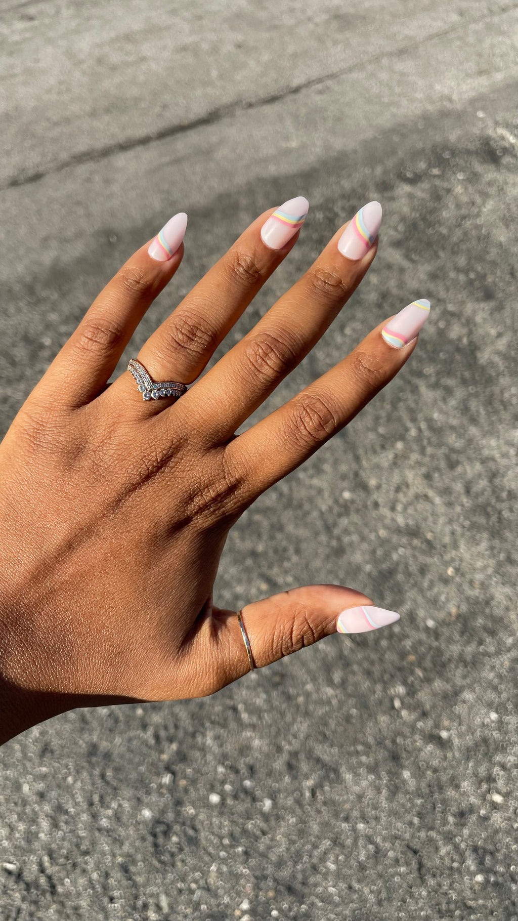 Rainbow Swirl - Press-On | Medium | Almond nails with pastel rainbow lines on neutral base for an easy at-home mani look