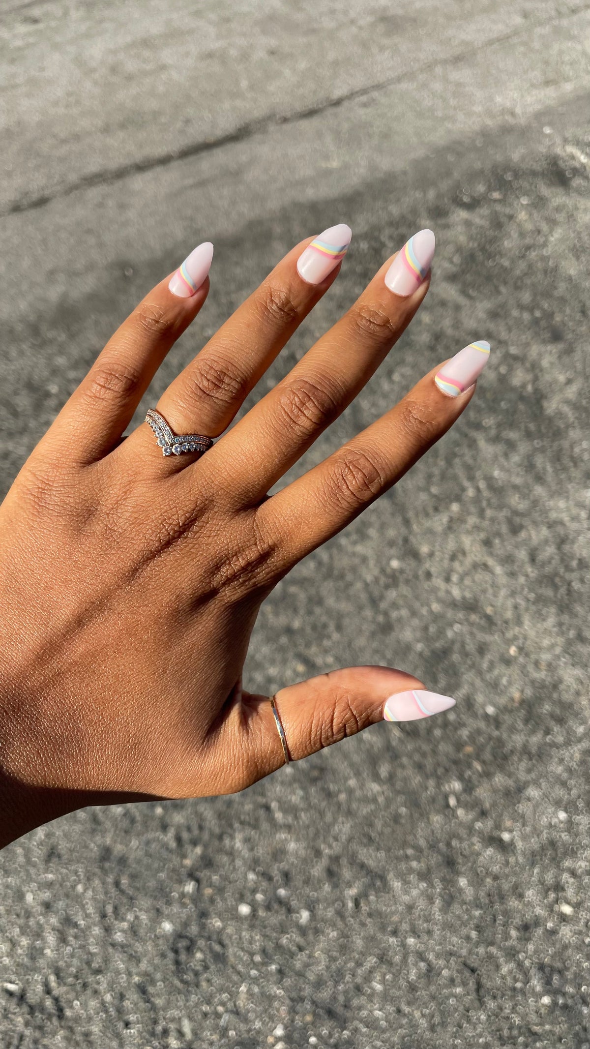 Rainbow Swirl - Press-On | Medium | Almond nails with pastel rainbow lines on neutral base for an easy at-home mani look