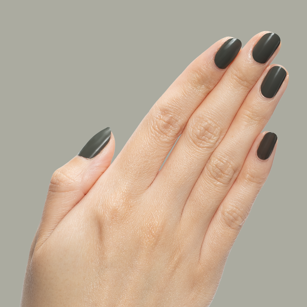 Hand with neatly shaped nails polished in "Is it Smoky in Here?" deep charcoal gray gel polish on neutral background
