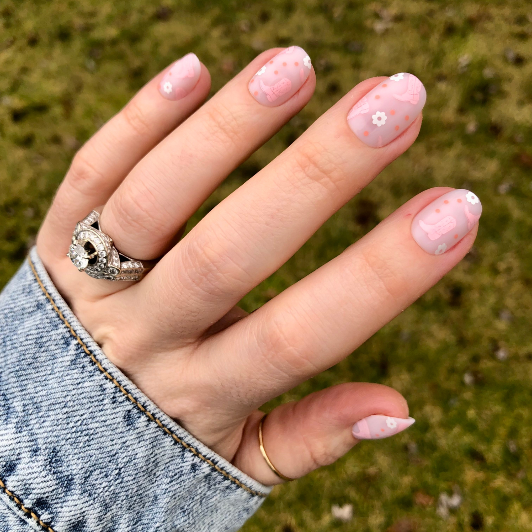 Cowgirl Boot Boogie - Press-On | Extra Short | Round showing pink floral and boot designs on short false nails outdoors