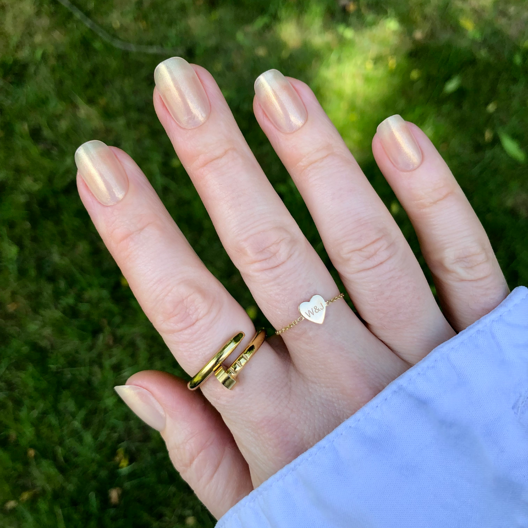 Team Manuscript - Press-On | Short | Squoval showing semi-sheer gold glazed short squoval press-on false nails on hand with rings outdoors