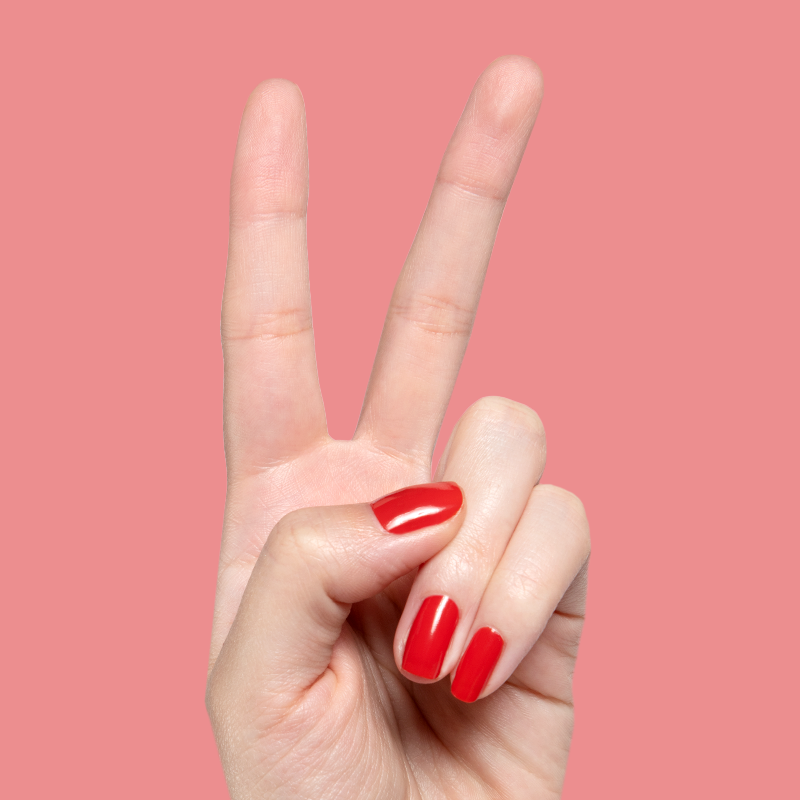 Hand showing bright glossy Let’s Circle Back gel polish manicure in vibrant orange-red on soft pink background