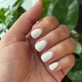 Hand with rounded nails painted in glossy soft white using LHG - Gel for a clean, polished mani look thumbnail