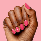 Hand with nails painted in bright hot pink Love All polish for a glossy and vibrant at-home manicure look