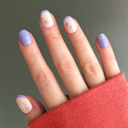 Mixed Purple Sparkle | Extra Short | Round - Tab Press-On nails with violet tips and star designs on natural base in soft light