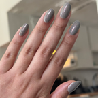 Hand showing nails painted with Moonlit quick dry gel polish in milky grey with holographic shimmer over natural skin tone