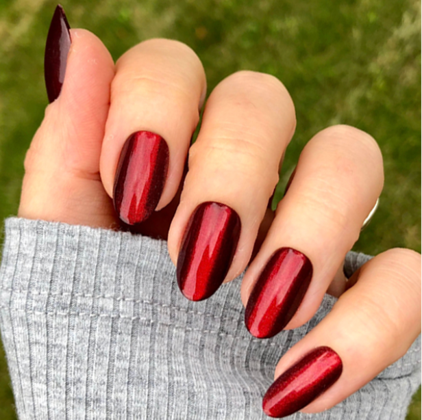 Obsessed Velvet - Press-On | Medium | Oval deep red cat eye velvet finish false nails on hand with gray sleeve