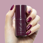 Plaza - Gel bottle held by hand with deep mulberry purple gel polish on nails for a luxe manicure by Olive and June
