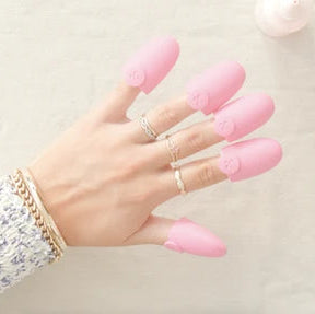 Hands with press-on nail removal caps