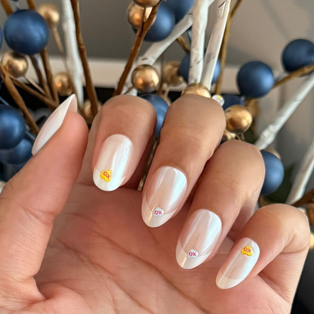 Hand with Puffy Chrome Candy Heart French - Press On | Medium | Oval nails featuring 3D candy heart accents indoors