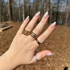 Purple Puka - Press-On | Medium | Almond showing iridescent lavender medium almond mani on hand with gold rings outdoors