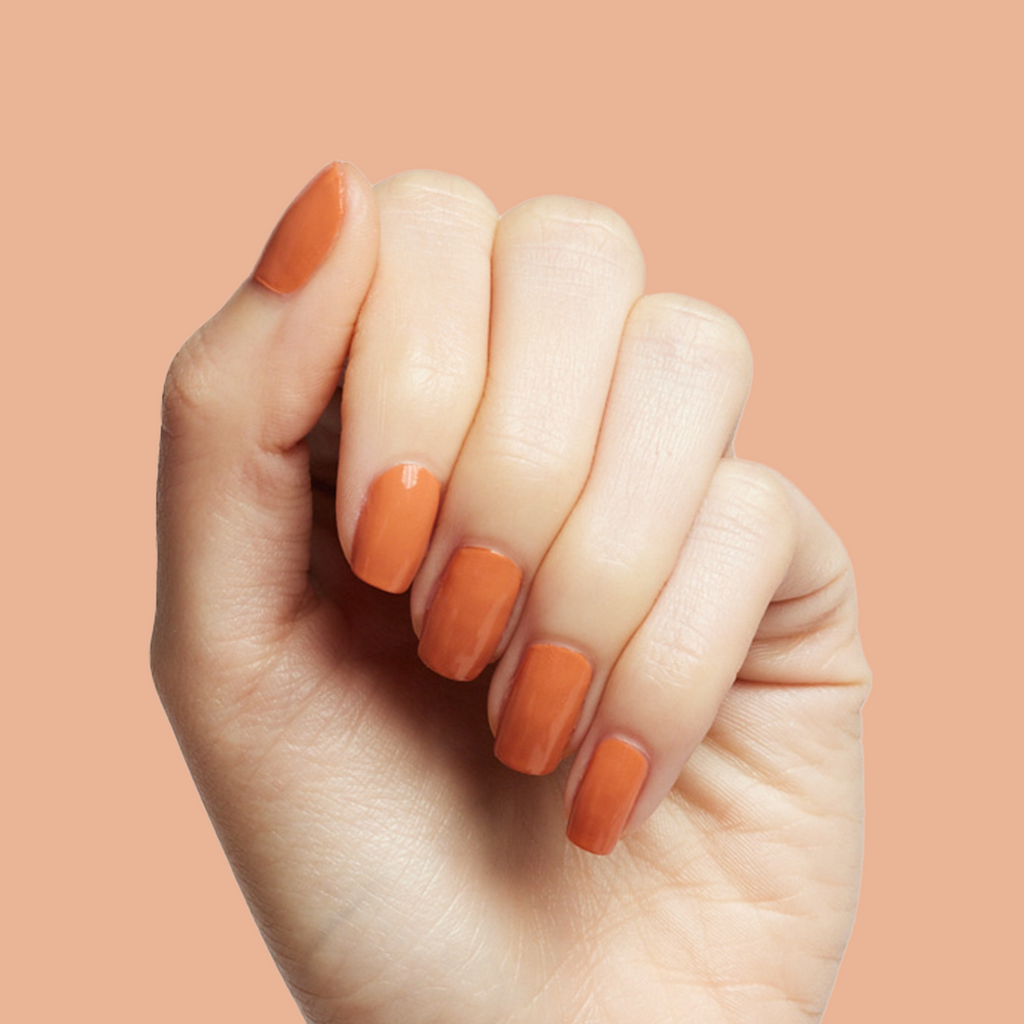 Hand displaying smooth Canyon gel polish nails in warm desert orange for easy at-home mani and manicure options