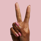 Hand showing two fingers painted with Primrose gel polish in warm rosey pink for a neat at-home mani