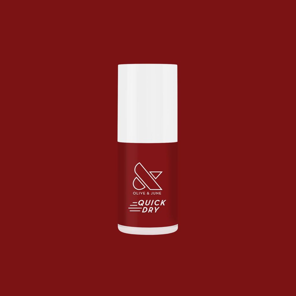 Olive and June quick dry nail polish bottle in deep red shade Brick on a matching deep red background
