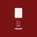 Olive and June quick dry nail polish bottle in deep red shade Brick on a matching deep red background