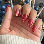 Close-up of hand wearing Red Illusion Velvet French - Press On | Medium | Almond nails with cherry red velvet and subtle french tip effect