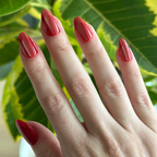 Hand with Red Illusion Velvet French - Press On | Medium | Almond false nails in glossy cherry red with subtle french tip effect near green leaves