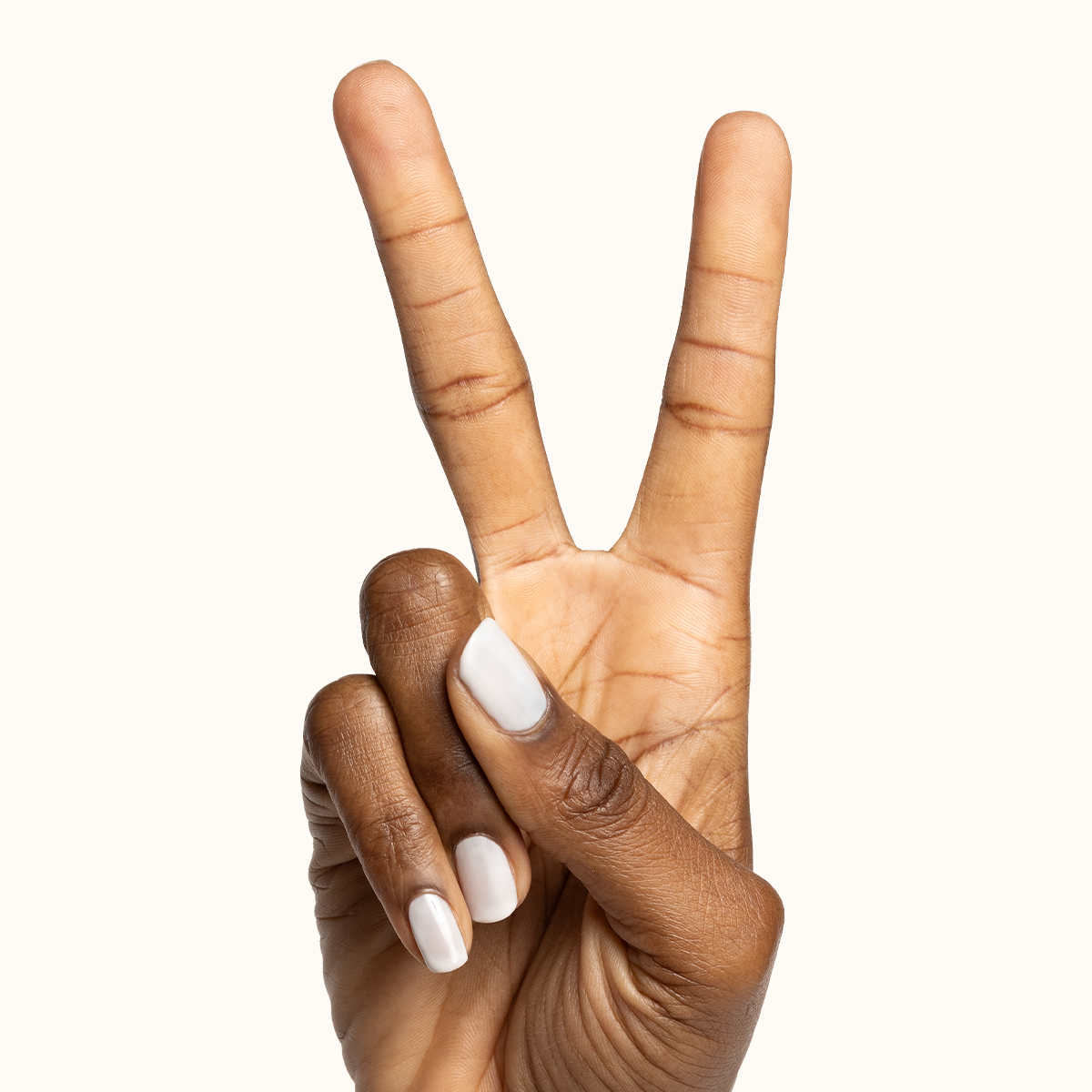 Hand showing two fingers with Buttercream sheer milky white polish on natural nails for a clean manicure look