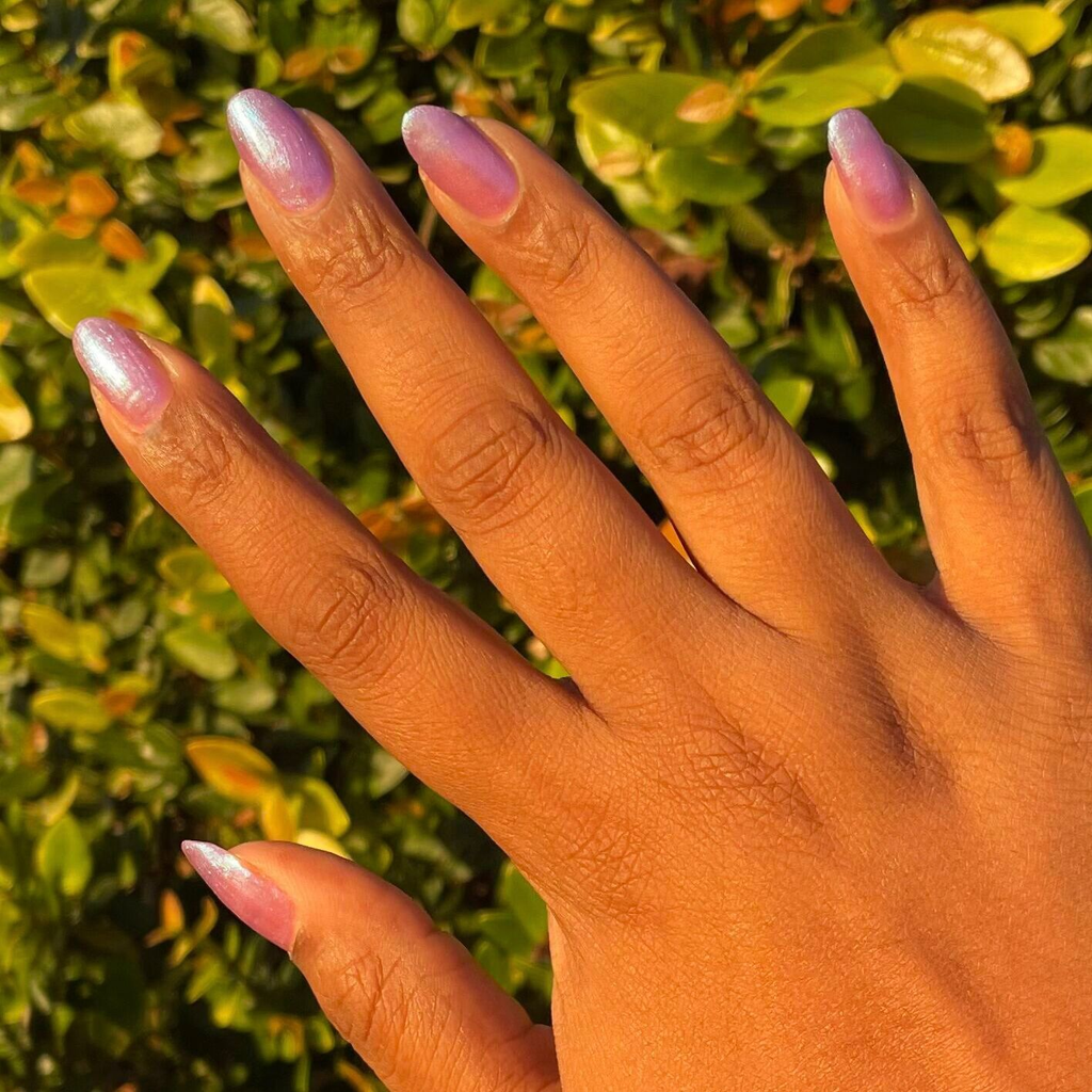 Hand with nails painted in jelly purple-blue iridescent duochrome using SWAK quick dry polish by Olive and June