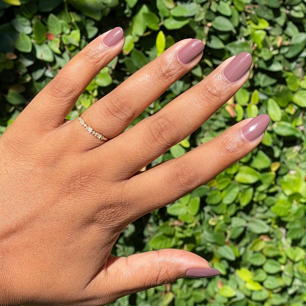 Hand with medium skin tone wearing smooth Sable gel polish manicure with natural nails outdoors in sunlight