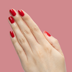 Hand with square-shaped nails painted in Secret Recipe classic blue-toned red polish against muted pink background