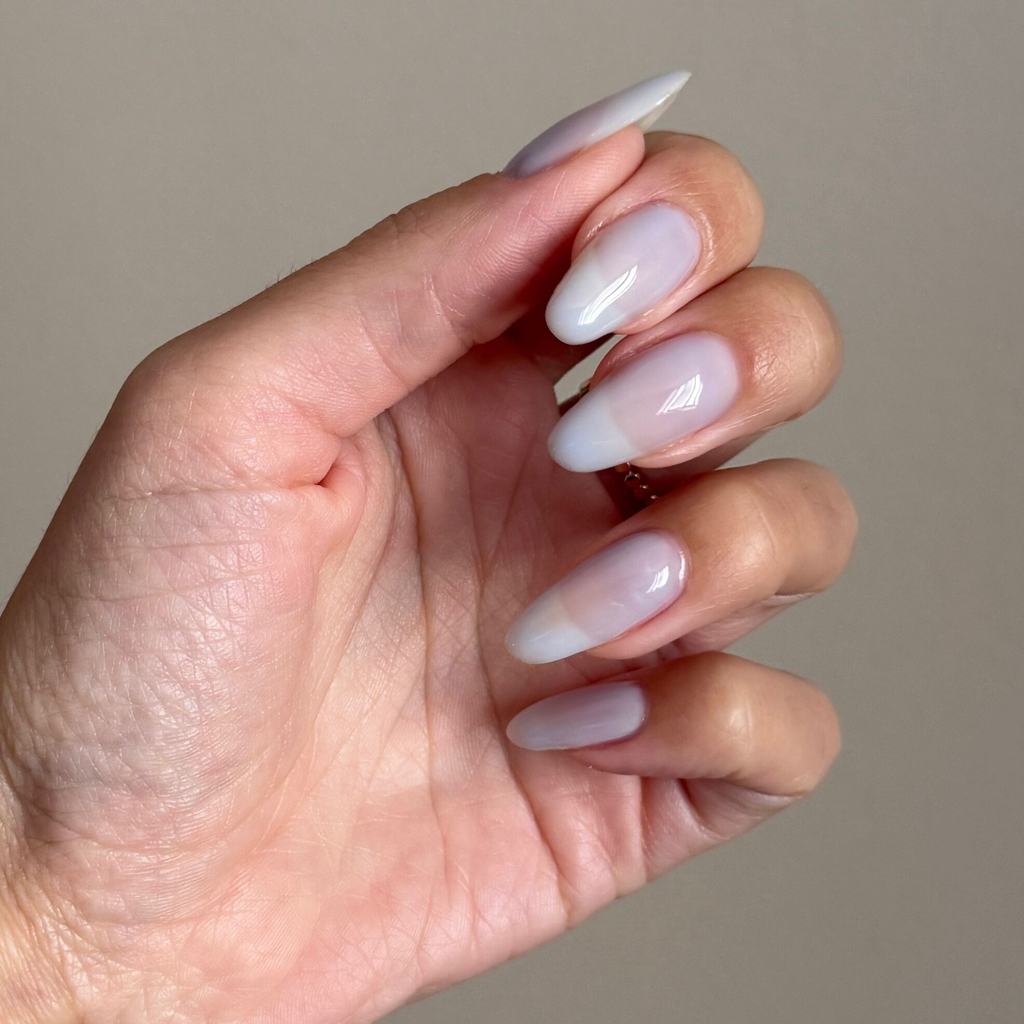 Sky Blue Filter - Builder Gel on almond-shaped nails with a translucent pastel blue manicure and glossy finish in natural light