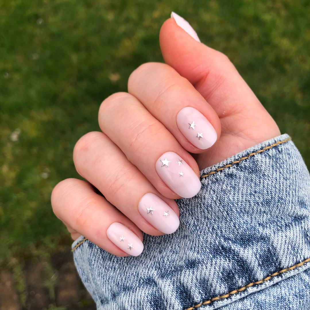 Soft Silver Foil Stars - Press-On | Short | Round showing short round press-on nails with neutral polish and 3D silver star accents outdoors