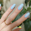 The Sparkle Fairy Effect Top Coat over pastel blue gel polish showing iridescent shimmer on almond-shaped nails for mani thumbnail