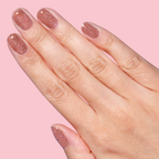 Hand with nails painted in glittery blush pink gel polish using Sparkly Pink Drink Gel on pink background