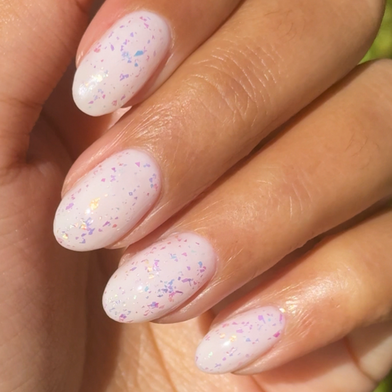 The Stardust Effect Top Coat on light polish with subtle holographic flakes for a delicate sparkling manicure finish