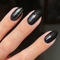 The Stardust Effect Top Coat on black polish displaying scattered holographic flakes for a vibrant manicure finish thumbnail